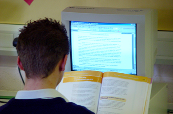 Un aprendiz con un libro frente a un ordenador